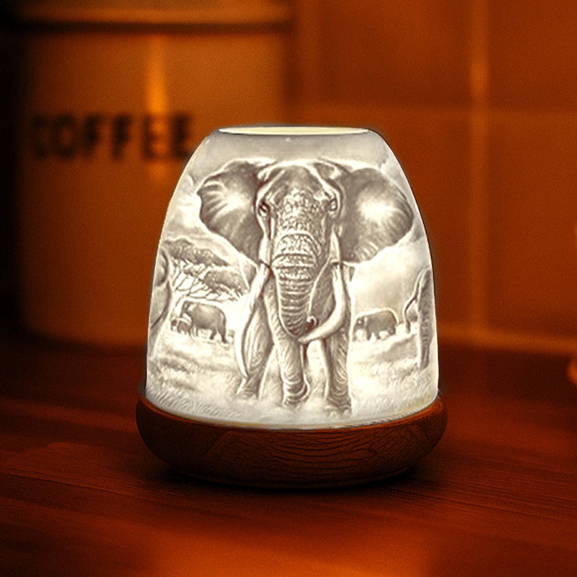 Warm glowing Cello porcelain elephant tealight dome creating ambient light.