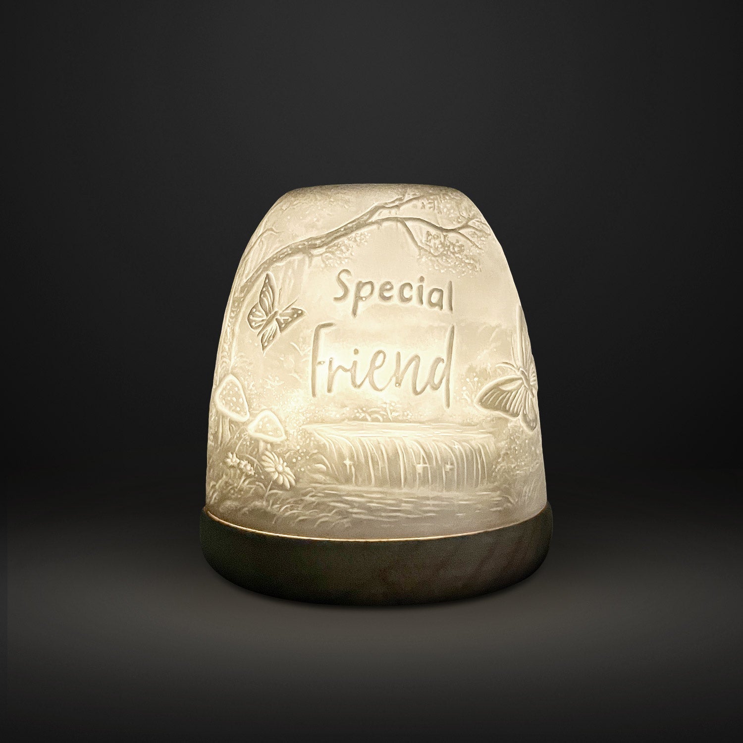 Cello Tall Tealight Dome Special Friend glowing porcelain candle holder on dark background.