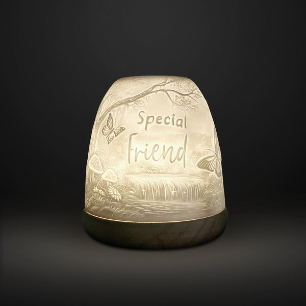 Cello Tall Tealight Dome Special Friend glowing porcelain candle holder on dark background.